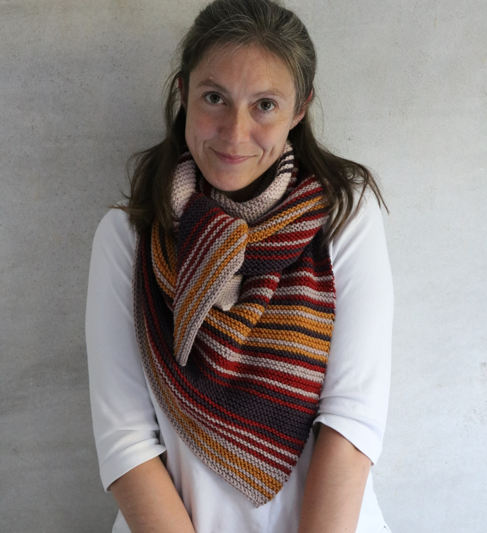 A woman wearing a cosy stripes shawl around her neck